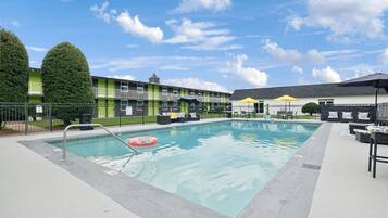 Alberca al aire libre, sombrillas en la alberca y camastros