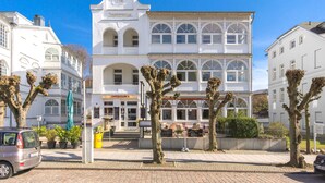 A white building with arched windows and a balcony, labeled 'Josef Dessau'. - Haus Johanneshorst (Sellin)