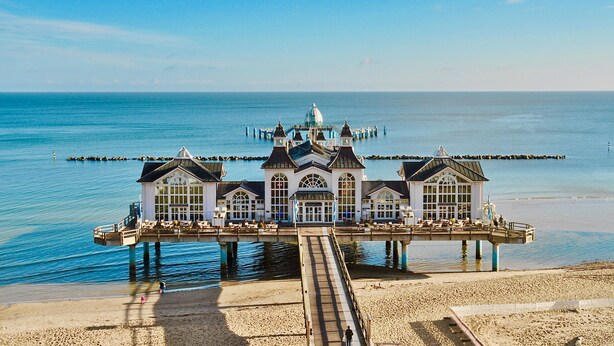 A waterfront hotel with a pier extending into the sea, featuring multiple rooms and a central dome structure. - Haus Johanneshorst (Sellin)