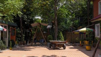 Un patio al aire libre con un carrito de madera, asientos y plantas en macetas.