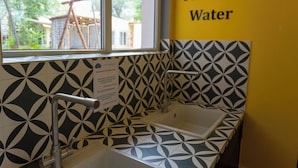 A bathroom with a window, a sink, and a wall sign that reads "Filtered Water". - Koisha Hostel (Bishkek)