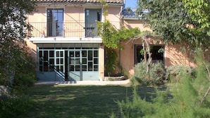 Una casa con jardín delantero, un porche cubierto y un pequeño jardín.