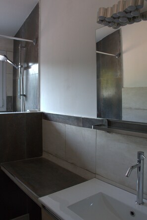 A modern bathroom with a large mirror, a sink, and a shower. - Mas Du Petit Claux (Barbentane)