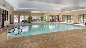 An indoor swimming pool with clear glass walls, a tiled floor, and a ceiling with recessed lighting. - Hilton Vacation Club The Falls Village Branson (Branson)