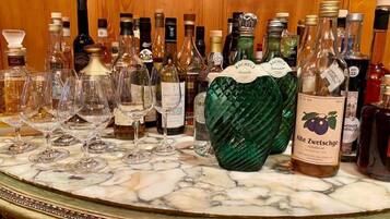 A bar area with various bottles and glasses on a marble countertop.