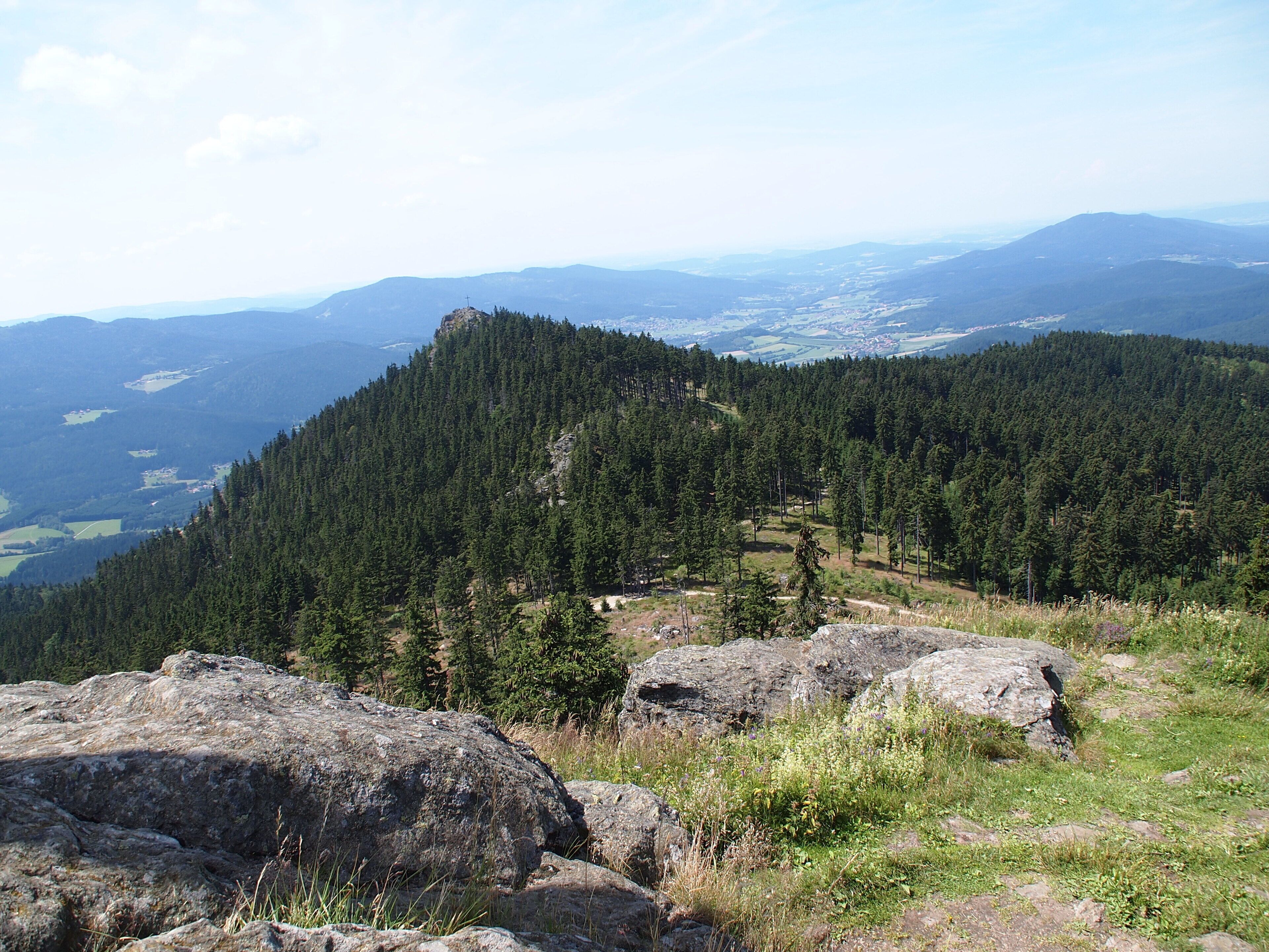 A mountainous landscape with dense forests and rocky terrain.