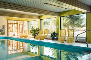 Una piscina techada, sillones reclinables de piscina