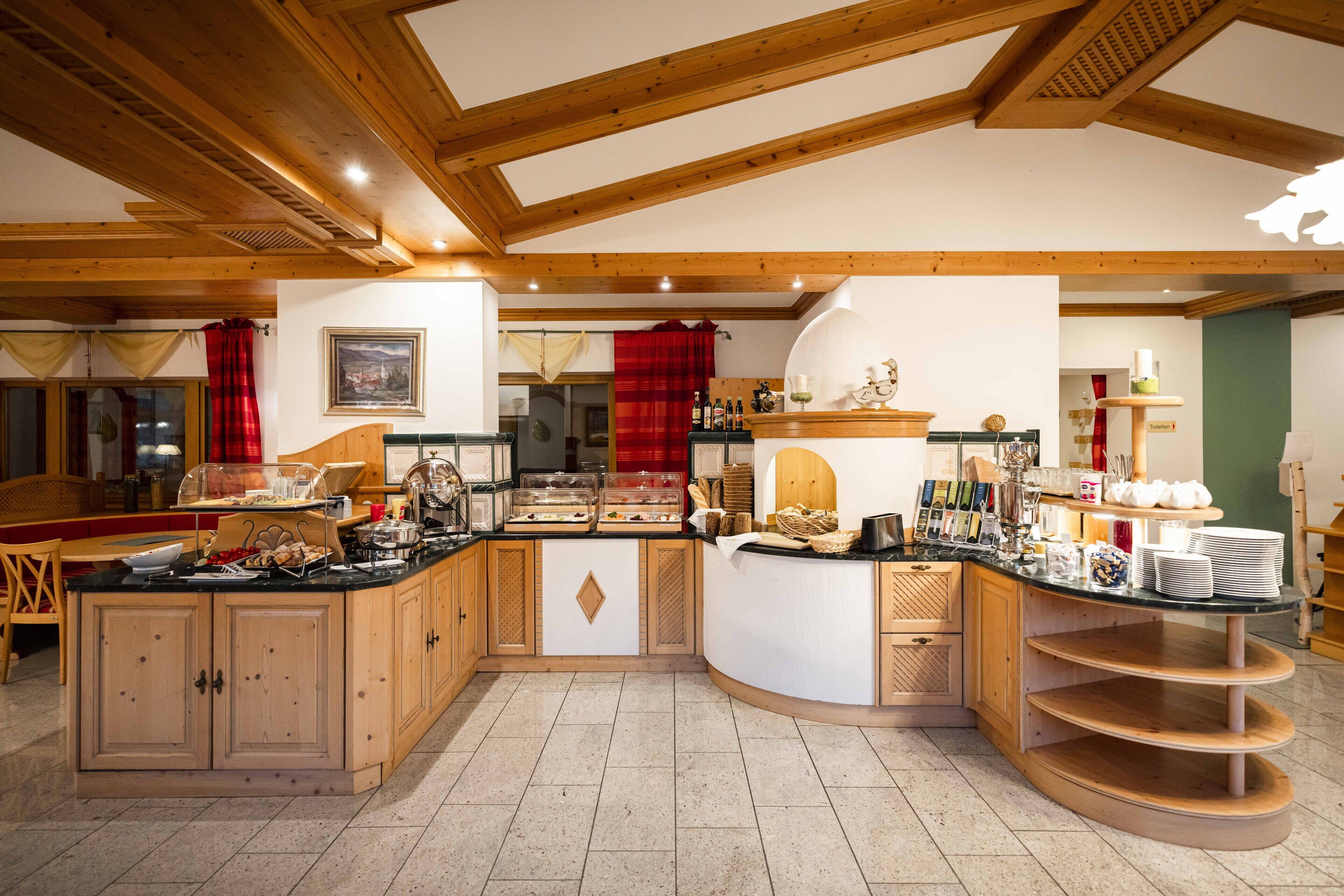 Une cuisine spacieuse avec des meubles en bois, un îlot central et un bar pour prendre le petit-déjeuner.