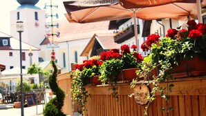 A wooden fence with red flowers and a hanging basket. - Bayerische Gastwirtschaft Dimpfl-Stadl (Lam)