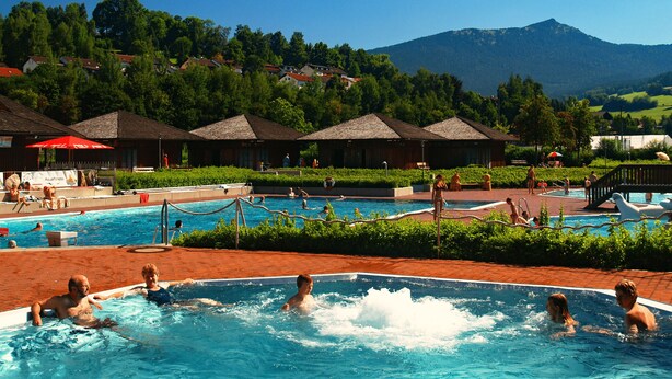 A swimming pool area with multiple pools, lounge chairs, and umbrellas. - Bayerische Gastwirtschaft Dimpfl-Stadl (Lam)