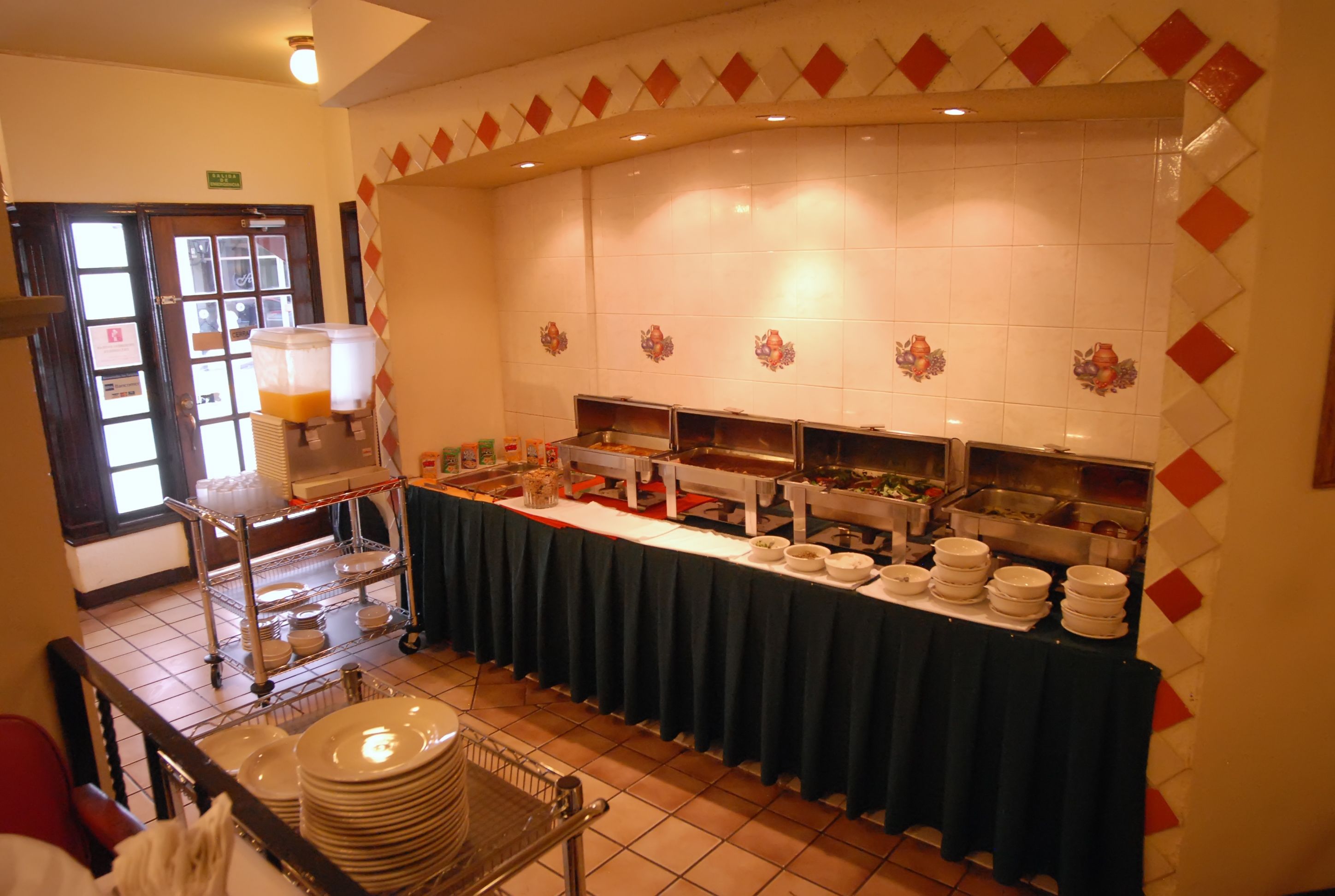 A buffet setup with a variety of food items and a beverage dispenser.