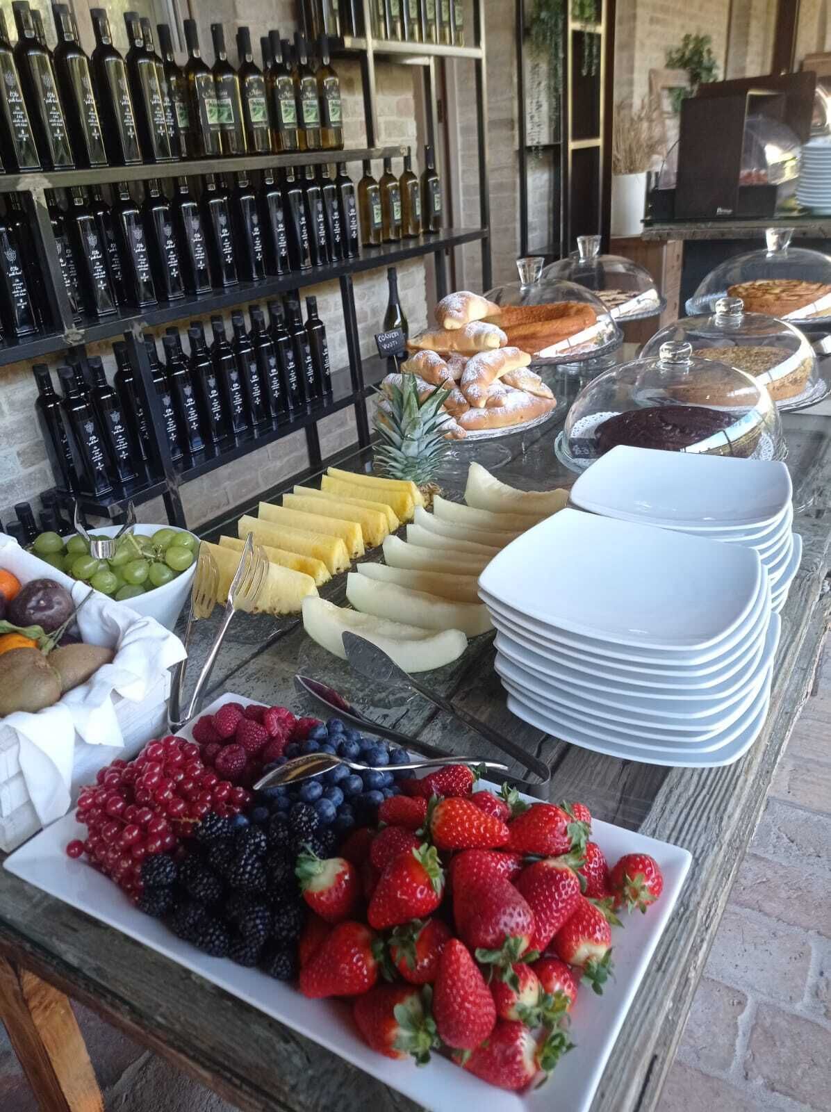 Un bufé con diversas frutas, quesos y pasteles.