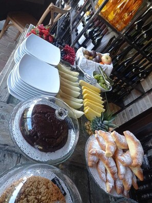 A table with various food items and a wine rack in the background.