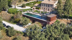 Un resort con piscina, un edificio grande y un castillo al fondo.