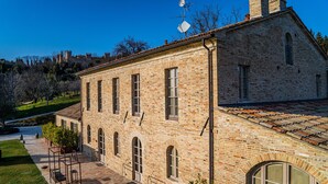 Un edificio histórico de ladrillo con un patio, ventanas amplias y una chimenea.