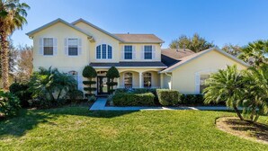 A two-story house with a front porch, a covered entryway, and a well-maintained lawn.