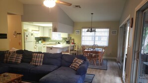 A living room with a dark blue sectional sofa, a glass coffee table, and a striped rug. - A PIECE OF PARADISE - MANATEE PLAYGROUND (Weeki Wachee)