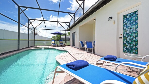 An indoor swimming pool with blue lounge chairs and a covered patio area. - Home from home! Updated - private pool & hot tub - gated resort (Clermont)