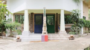 A building entrance with a stone pillar, steps, and a door.