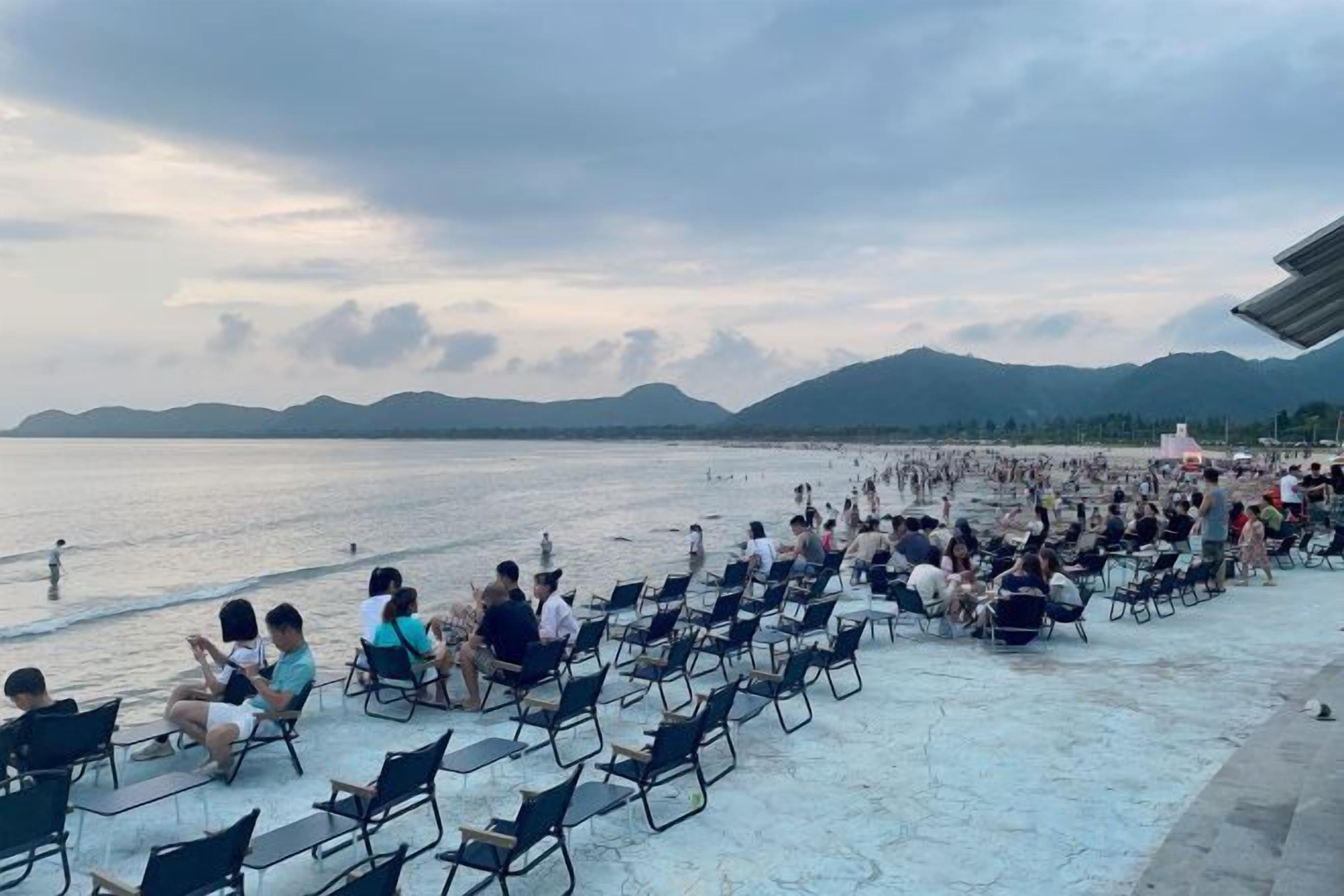 A beachside seating area with rows of chairs facing the water.