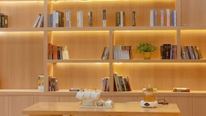 Ein Bücherregal aus Holz mit Büchern und einer Topfpflanze.