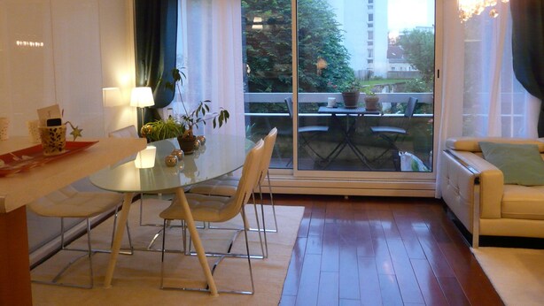 A modern living room with a glass dining table, comfortable seating, a sofa, and a view of a building and greenery outside. - Sweet Home Paris 12ème in lush greenery. Well located (Paris)