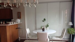 A modern dining area with a round table, white chairs, and a potted plant. - Sweet Home Paris 12ème in lush greenery. Well located (Paris)