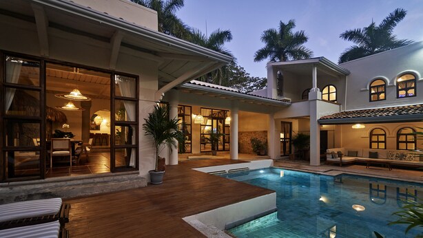 A poolside area with a wooden deck, a lounge chair, and a pool. - Paradise Beach Lodge (Cóbano)
