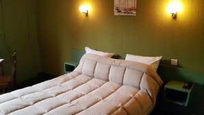 A neatly made bed with a quilted duvet, two bedside tables with lamps, and a painting on the wall. - L'Agapanthe (Pont-de-Salars)