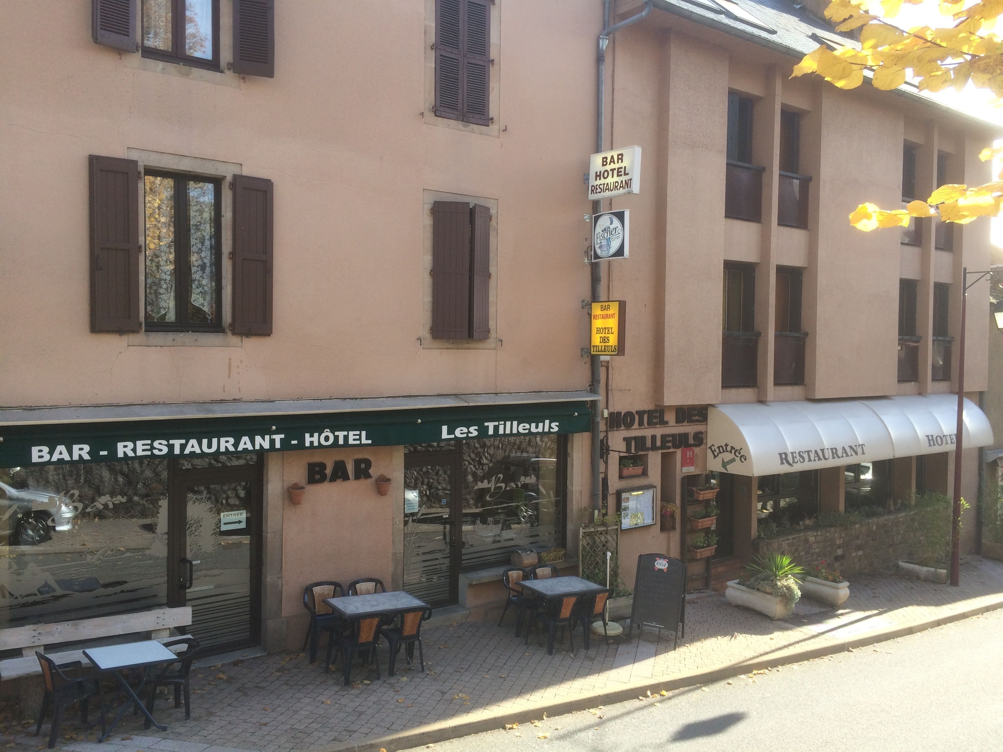 Un bâtiment qui abrite un bar, un restaurant et un hôtel. On y trouve des tables et des chaises à l’extérieur.