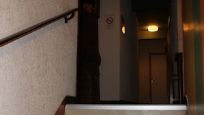 A staircase with beige carpeted steps and metal handrails, leading to a door at the top. - L'Agapanthe (Pont-de-Salars)