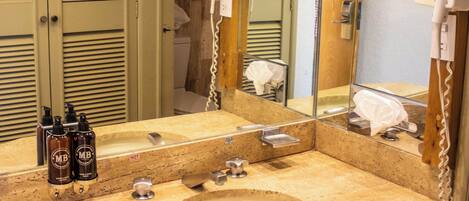 A bathroom with a double sink, a mirror, and a hairdryer.