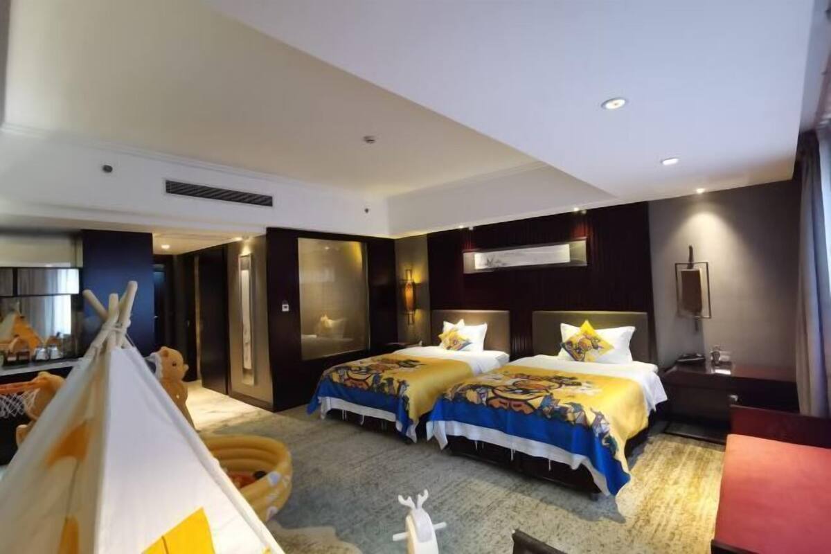 A hotel room with two beds, a tent, and a large window.
