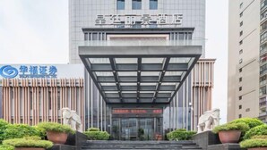 A modern building with a glass entrance and a sign above it. - Huangting Lijing Hotel (Sanming)