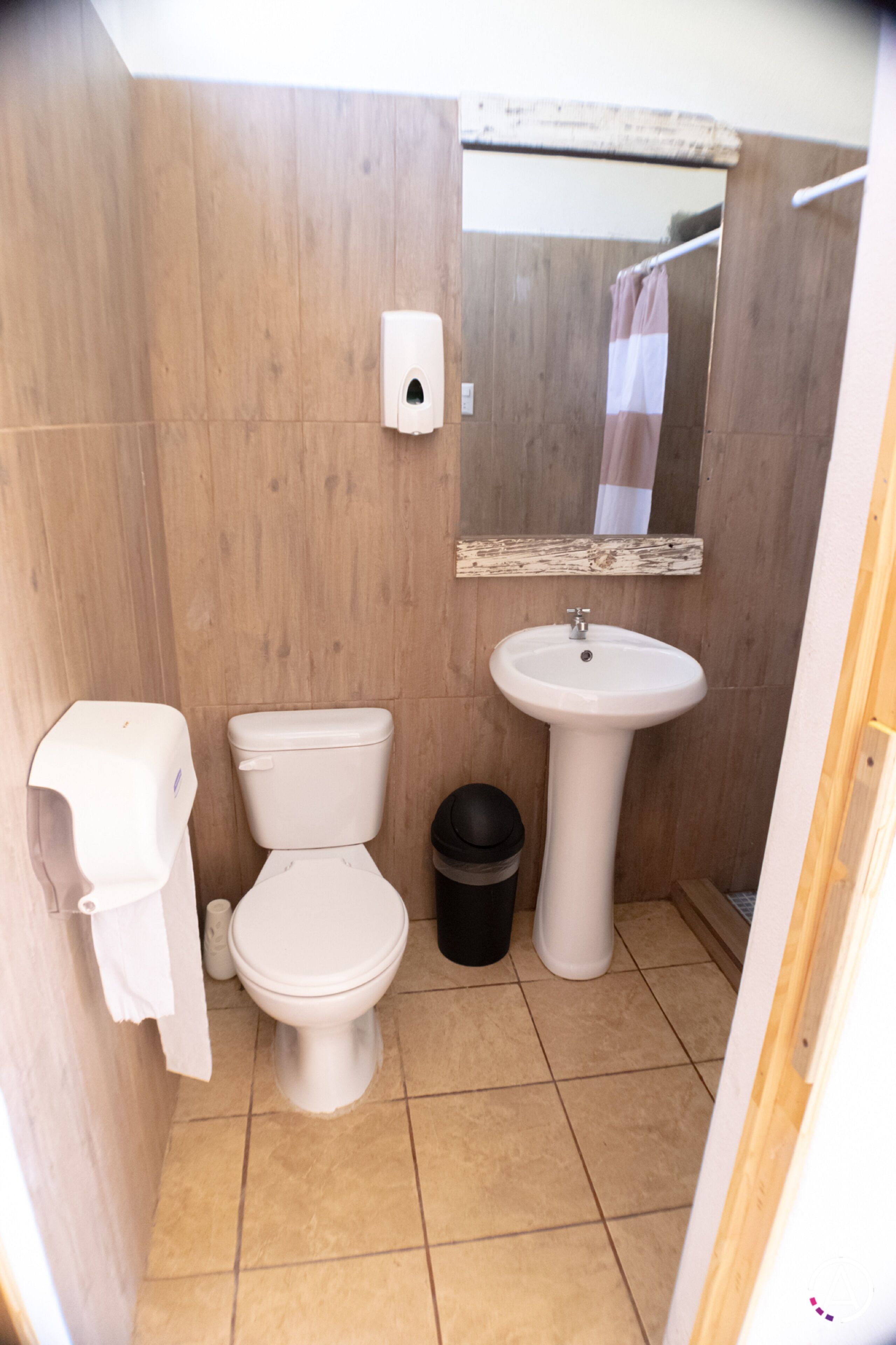 Une petite salle de bain avec des toilettes, un lavabo et une poubelle.
