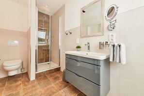 A modern bathroom with a shower, toilet, vanity, and a large mirror. - Rochter Landhotel (Zeltingen-Rachtig)