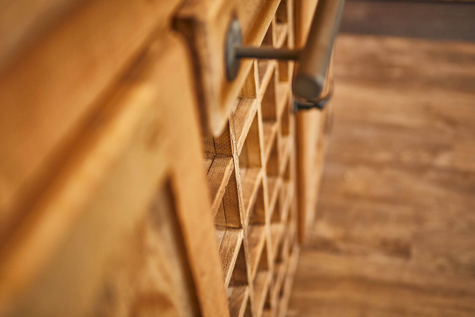 A close-up of a wooden lattice structure, likely part of a fence or railing.