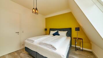 A bedroom with a bed, a nightstand, a lamp, and a ceiling light.