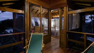 Cozy cabin with a simple, rustic design, featuring a comfortable seating area and large windows offering a view of the surrounding landscape.