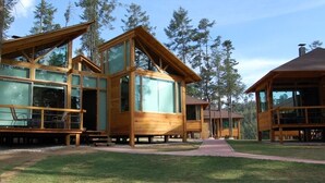 A wooden cabin with large windows and a covered porch. - Quinta Los Azufres (Ciudad Hidalgo)