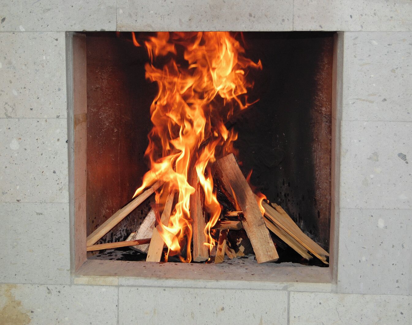 Ein Kamin mit brennenden Holzscheiten.