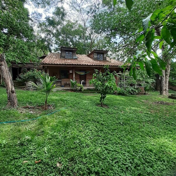 A rustic house with a tiled roof, surrounded by lush greenery and trees. - BEAUTYFUL, CASA DEL CAMPO (Quezaltepeque)