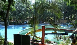 A pool area with multiple slides and surrounding greenery. - BEAUTYFUL, CASA DEL CAMPO (Quezaltepeque)