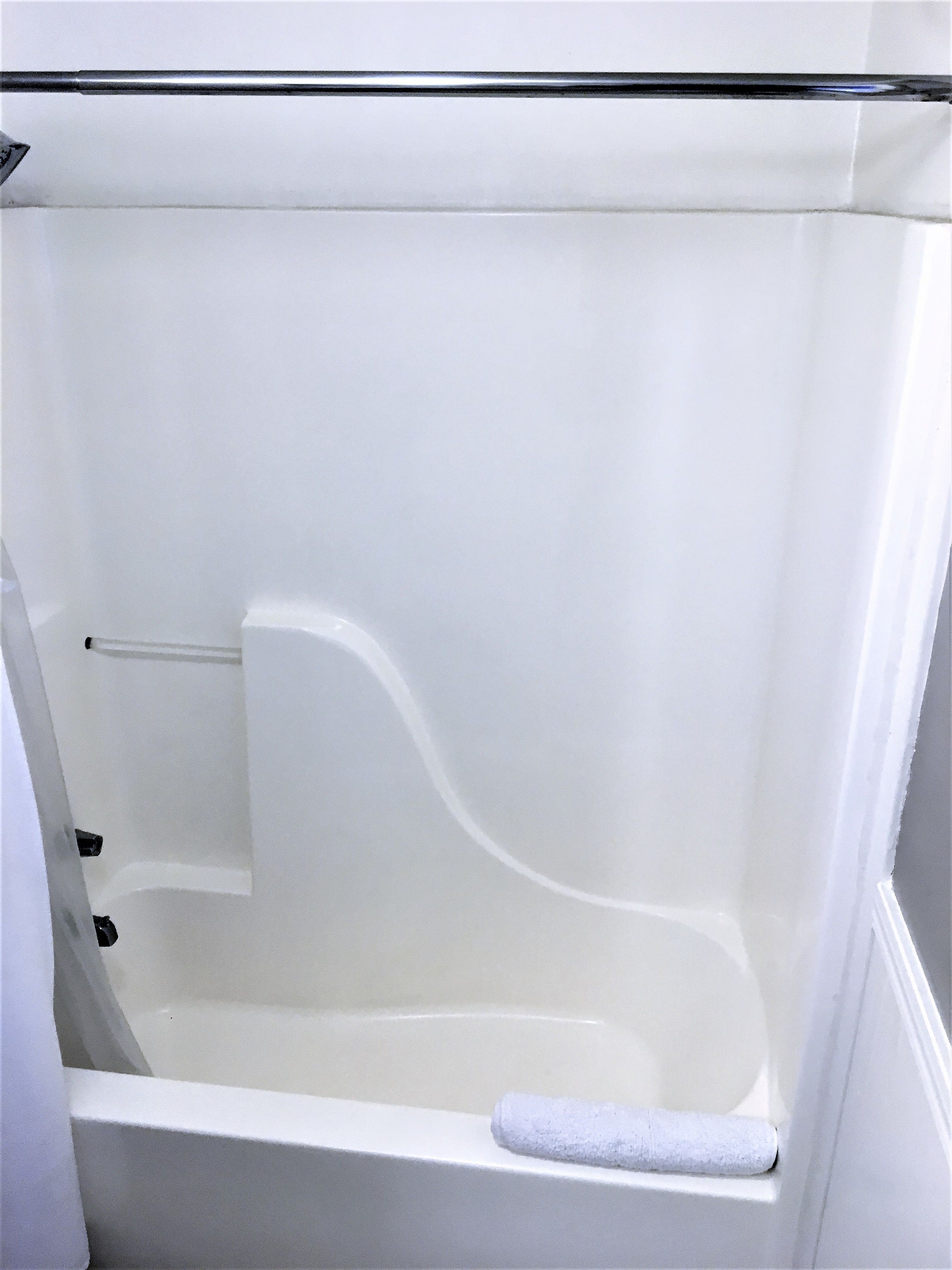 Une baignoire blanche avec une seule serviette.