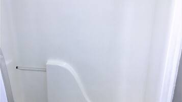 A white bathtub with a single towel.