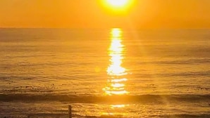 Un atardecer sobre un mar tranquilo con horizonte despejado.