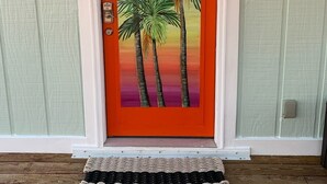 Una porta con un vivace dipinto del tramonto raffigurante palme.