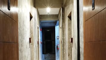 A hallway with wooden paneling and a light fixture on the ceiling.
