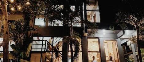 Un bâtiment moderne doté d’une façade en verre, d’une terrasse et d’un escalier menant à un étage supérieur.