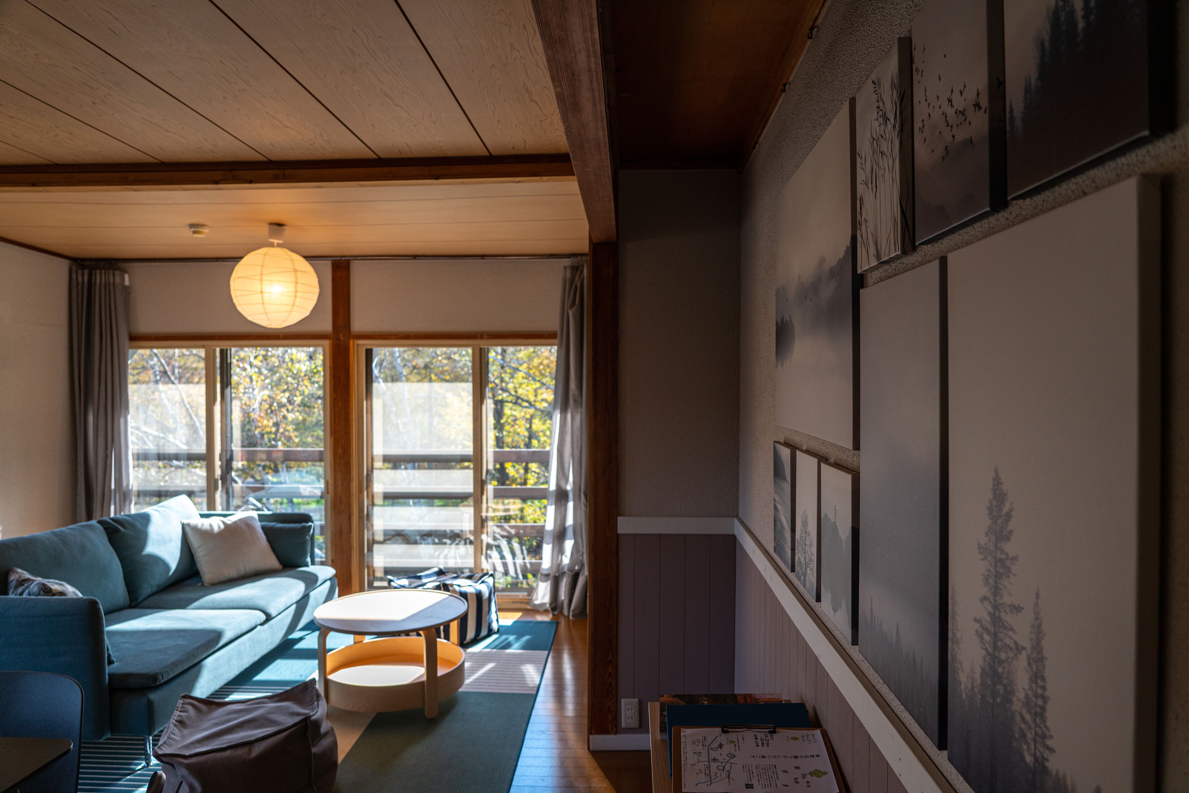 A cozy living room with a sofa, a round table, and a large window.